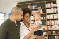 Couple holding baby in living room at home — Stock Photo