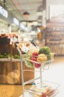 Produce and groceries in shopping cart in market — Stock Photo