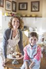 Happy beautiful grandmother and granddaughter smiling in kitchen — Stock Photo
