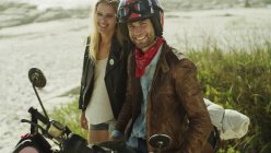 Портрет посміхаючись молода пара на мотоциклі на пляжі — стокове фото