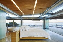 Modern luxury bedroom open to patio with ocean view — Stock Photo