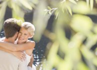 Casal abraço por piscina ao ar livre — Fotografia de Stock