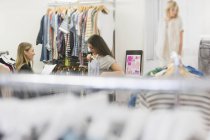 Compradores de moda examinando roupas juntos — Fotografia de Stock