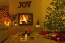 Lareira ambiente e velas na sala de estar com árvore de Natal — Fotografia de Stock