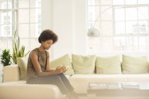 Geschäftsfrau nutzt digitales Tablet zu Hause auf dem Sofa — Stockfoto