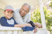 Дедушка и внук в бейсбольной перчатке на крыльце — стоковое фото