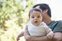 Father carrying baby girl outdoors — Stock Photo