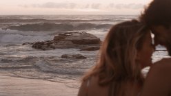 Ласковая пара обнимается на берегу океана — стоковое фото
