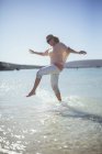 Женщина плескается в воде на пляже — стоковое фото