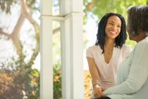 Happy mother and daughter talking on porch — Stock Photo