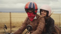 Jeune couple à moto dans la campagne rurale — Photo de stock