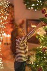 Fille pendaison ornement sur arbre de Noël — Photo de stock