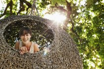 Mulher sorrindo na casa da árvore ninho — Fotografia de Stock