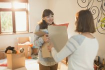 Mother helping young adult daughter moving into new apartment — Stock Photo