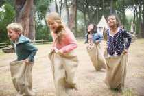 Crianças tendo corrida saco em campo — Fotografia de Stock