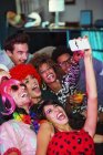 Amigos tomando auto-retrato com telefone câmera na festa — Fotografia de Stock