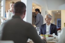 Man smiling at table at dinner party — Stock Photo