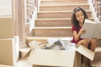 Young girl reading while sitting on stairs — Stock Photo