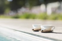 Cappuccino cups at poolside — Stock Photo