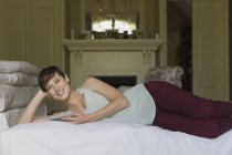 Young woman lying on bed at room — Stock Photo