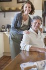 Happy older couple relaxing in the kitchen — Stock Photo