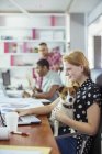 Dog sitting on woman?s lap in office — Stock Photo
