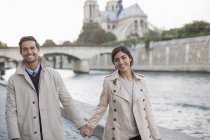 Couple tenant la main le long de la Seine près de la Cathédrale Notre Dame, Paris, France — Photo de stock