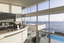 Moderna casa di lusso vetrina home office interno con soleggiata vista sull'oceano — Foto stock
