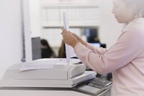 Donna d'affari che fa copie a fotocopiatrice in ufficio — Foto stock