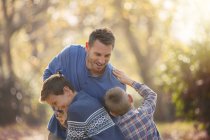 Playful father and sons rough housing outdoors — Stock Photo
