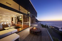 Роскошный современный дом на рассвете над морем — стоковое фото