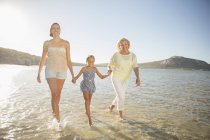Três gerações de mulheres caminhando em ondas — Fotografia de Stock