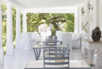 Luxury patio with table and chairs against trees — Stock Photo