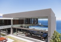 Modern house overlooking ocean water — Stock Photo
