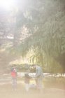 Pai e filhos preparando varas de pesca em florestas — Fotografia de Stock