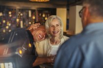 Affettuosa coppia anziana ridere e abbracciarsi nel bar — Foto stock