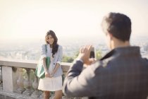 Man photographing girlfriend with Paris in background — Stock Photo