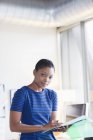 Портрет уверенной предпринимательницы с бумажной работой в современном офисе — стоковое фото