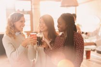 Freundinnen stoßen an der Bar auf Biergläser an — Stockfoto