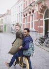 Porträt lächelnder junger Mann und Frau mit Fahrrad auf der Stadtstraße — Stockfoto