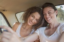 Sisters taking picture together on cell phone — Stock Photo