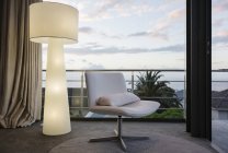 Moderna lampada da terra e sedia in angolo soggiorno — Foto stock