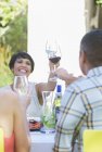 Friends toasting each other at table outdoors — Stock Photo