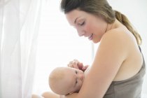 Allegro madre che allatta al seno bambina — Foto stock