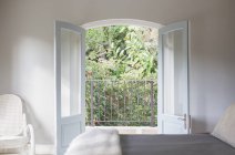 Французские двери открываются на балкон в роскошной спальне — стоковое фото