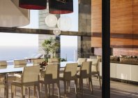 Mesa e cadeiras na moderna sala de jantar com vista para o mar — Fotografia de Stock