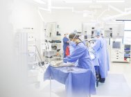 Equipe de cirurgiões que realizam cirurgia em sala de operações — Fotografia de Stock