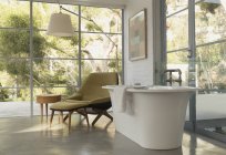 Замочування ванни в домашній вітрині інтер'єру спальні з видом на сад — стокове фото