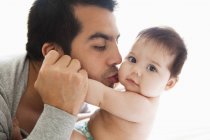 Отец целует очаровательную малышку — стоковое фото