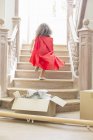 Young girl running up stairs playing — Stock Photo